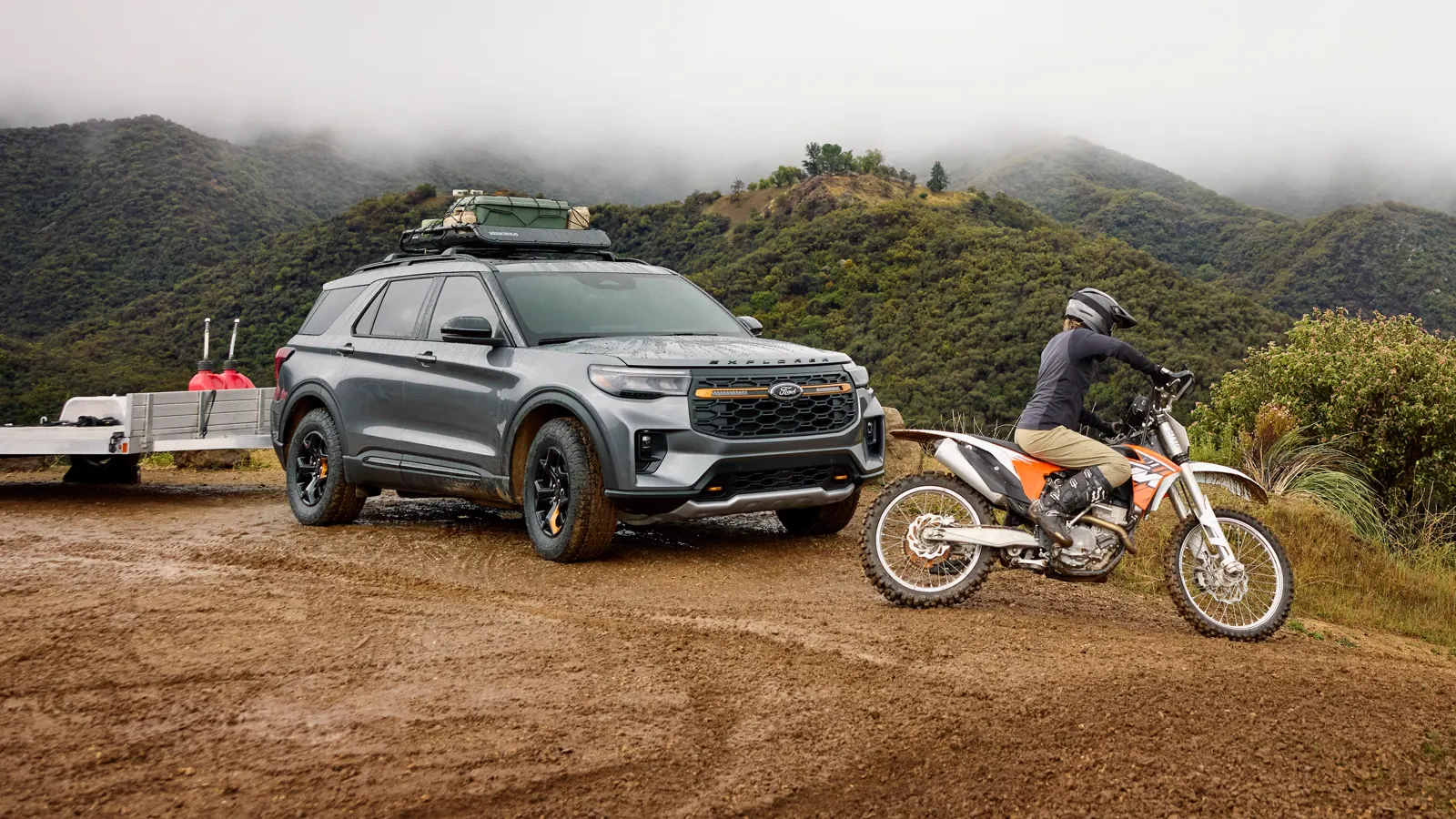 Gray Ford Explorer Tremor with a dirt bike on a trail