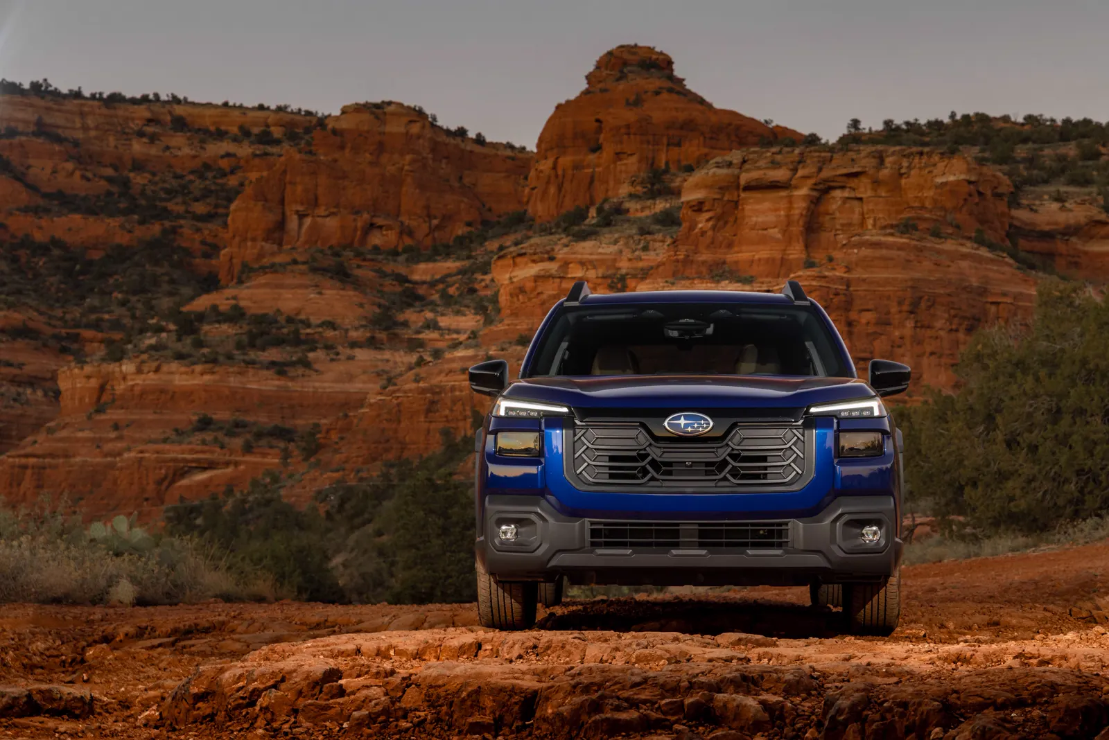 Blue Subaru Outback on red desert rock